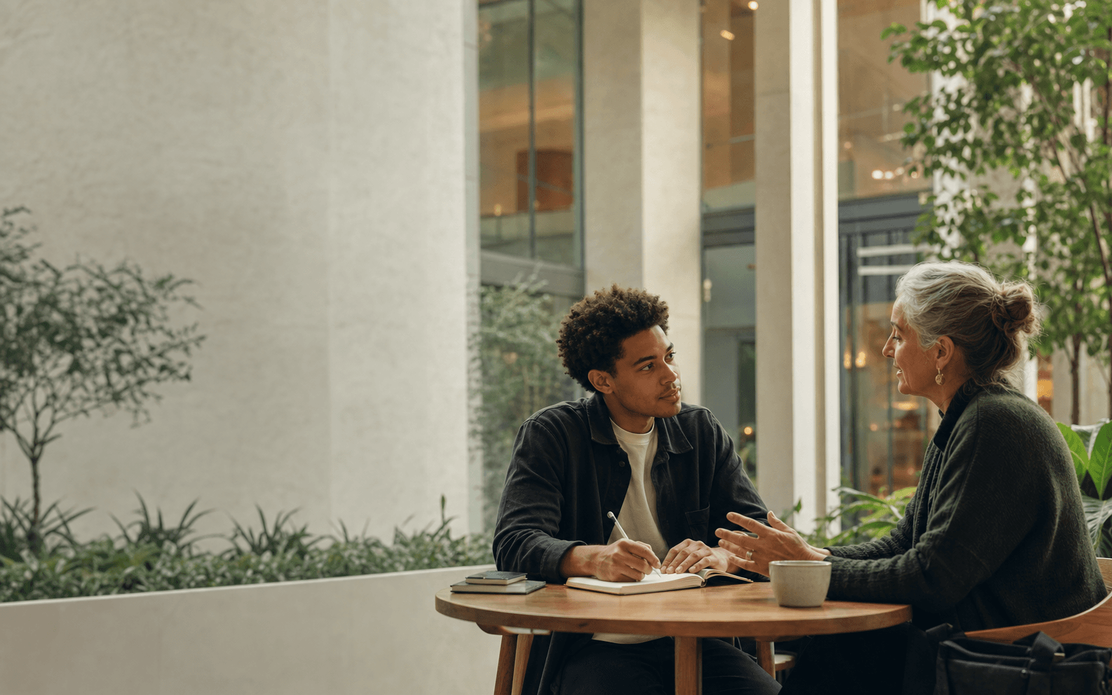 A mentor and mentee sharing an encouraging conversation in a warm, modern setting